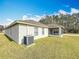 Home exterior featuring screened patio and a well-manicured lawn at 7541 Mariners Harbour Dr, Wesley Chapel, FL 33545