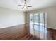 Open-concept living room with wood floors and sliding door to the screened patio at 7541 Mariners Harbour Dr, Wesley Chapel, FL 33545