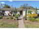 Charming home featuring meticulously landscaped front yard with mature trees and vibrant flower beds at 921 39Th Ne Ave, St Petersburg, FL 33703