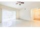 Bright living room features tile flooring, ceiling fan, and sliding glass door for natural light at 13304 Sanctuary Cove Dr # 303, Temple Terrace, FL 33637