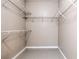 Walk-in closet with built-in shelving and gray tile floors offers ample storage and organization at 13304 Sanctuary Cove Dr # 303, Temple Terrace, FL 33637