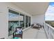 Spacious balcony with modern furniture, glass railings, and a beautiful view of the water and sky at 1020 Sunset Point Rd # 510, Clearwater, FL 33755