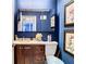 Bathroom featuring blue walls, decorative paintings and a vanity with a sink and brown cabinets at 110 Aspen Cir, Seminole, FL 33777