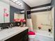 Bathroom featuring a vanity with dark cabinets and a bathtub with patterned shower curtain at 110 Aspen Cir, Seminole, FL 33777