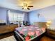 Cozy bedroom with hardwood floors, floral bedding, ceiling fan and dresser at 110 Aspen Cir, Seminole, FL 33777