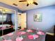 Cozy bedroom featuring light blue walls, ceiling fan, and a mirrored closet at 110 Aspen Cir, Seminole, FL 33777
