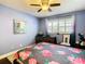 Cozy bedroom with hardwood floors, floral bedding, ceiling fan and shuttered window at 110 Aspen Cir, Seminole, FL 33777