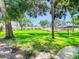 Grassy common area on a sunny day with mature trees at 110 Aspen Cir, Seminole, FL 33777
