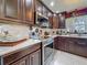 Kitchen featuring stainless steel appliances, dark wood cabinets, marble tile flooring, and a large window at 110 Aspen Cir, Seminole, FL 33777