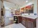Open kitchen with stainless steel appliances, dark wood cabinets, marble tile floors, and an open layout at 110 Aspen Cir, Seminole, FL 33777