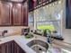 Kitchen sink featuring dark wood cabinets, marble countertops, window with a view, and stainless steel fixtures at 110 Aspen Cir, Seminole, FL 33777