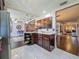 Kitchen featuring stainless steel appliances, dark wood cabinets, marble tile flooring, and an open layout at 110 Aspen Cir, Seminole, FL 33777