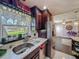 Kitchen sink area featuring stainless steel appliances, dark wood cabinets, marble tile flooring, and a window at 110 Aspen Cir, Seminole, FL 33777