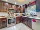 Kitchen featuring stainless steel appliances, dark wood cabinets, marble tile flooring, and a window at 110 Aspen Cir, Seminole, FL 33777