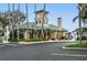 Attractive clubhouse with a beige facade, green tile roof, and lush palm tree landscaping at 1213 Bay Club Cir, Tampa, FL 33607