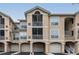 Three-story condo building with light brown stucco, garages, and screened in balconies at 1213 Bay Club Cir, Tampa, FL 33607