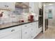 Modern kitchen with stainless steel appliances, stone backsplash, and white cabinets at 1213 Bay Club Cir, Tampa, FL 33607