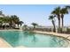 Inviting community pool surrounded by lounge chairs and tropical palm trees at 1213 Bay Club Cir, Tampa, FL 33607