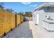 View of a side yard with white gravel, a wooden fence, and access to the main backyard at 1272 80Th N Ave, St Petersburg, FL 33702