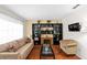 Cozy living room featuring a large bookshelf, comfortable seating, and hardwood floors at 13003 Lorna Pl, Tampa, FL 33618