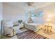 Bright bedroom with a single bed, recliner, natural light, and a colorful area rug at 1421 Monte Carlo Dr, Clearwater, FL 33764