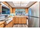 Classic kitchen with wood cabinetry, unique cooktop, stainless steel refrigerator, and bright window at 1421 Monte Carlo Dr, Clearwater, FL 33764