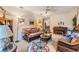 Comfortable living room featuring wicker furnishings, neutral carpeting, and a ceiling fan at 1421 Monte Carlo Dr, Clearwater, FL 33764
