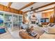 Cozy living room with a brick fireplace, beamed ceilings, and sliding glass doors to the backyard at 1421 Monte Carlo Dr, Clearwater, FL 33764