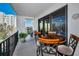 Wide balcony with patio table and chairs, offering views of the surrounding buildings and landscaping at 150 Belleview Blvd # 307, Belleair, FL 33756