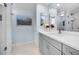 Elegant bathroom featuring a modern vanity with a sleek countertop, a decorative mirror, and ample lighting at 150 Belleview Blvd # 307, Belleair, FL 33756