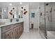 Bathroom featuring dual mirrors, gray vanity and a glass shower at 150 Belleview Blvd # 307, Belleair, FL 33756
