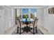 Bright dining area featuring a glass table, cushioned chairs, and sliding glass doors leading to a balcony with a view at 150 Belleview Blvd # 307, Belleair, FL 33756