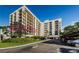 Modern high-rise condo building with multiple balconies and covered parking under a clear blue sky at 150 Belleview Blvd # 307, Belleair, FL 33756