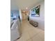 Hallway with light tile flooring leading past tropical inspired decor at 150 Belleview Blvd # 307, Belleair, FL 33756