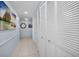 Bright hallway featuring white tile flooring and ample storage with louvered closet doors at 150 Belleview Blvd # 307, Belleair, FL 33756