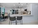 Open kitchen with white cabinetry, quartz countertops, stainless appliances, and an inviting breakfast bar at 150 Belleview Blvd # 307, Belleair, FL 33756