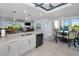 Modern kitchen with white cabinets, stainless steel appliances, and an island with seating, open to living and dining areas at 150 Belleview Blvd # 307, Belleair, FL 33756