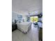 Serene main bedroom with white bedding, tile floors, ceiling fan, and balcony access at 150 Belleview Blvd # 307, Belleair, FL 33756