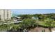 Exterior view features ample parking, lush green trees, and a tranquil pond enhancing the landscape at 150 Belleview Blvd # 307, Belleair, FL 33756