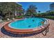 The community pool has clear blue water, surrounded by brick pavers and lounge chairs at 150 Belleview Blvd # 307, Belleair, FL 33756