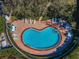 Aerial view of a kidney-shaped pool with a brick patio, surrounded by lounge chairs and greenery at 150 Belleview Blvd # 307, Belleair, FL 33756
