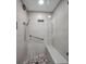 Modern shower with gray tile surround, shower bench, and rainfall shower head at 150 Belleview Blvd # 307, Belleair, FL 33756