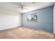 Cozy bedroom featuring two-toned walls, carpeted floors, a ceiling fan, and an exterior view through a large window at 1517 Danbury Dr, Sun City Center, FL 33573