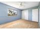 A tranquil bedroom featuring soft blue walls, a ceiling fan, and a bright window view at 1517 Danbury Dr, Sun City Center, FL 33573