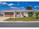 Charming single-story home with a well-manicured lawn, a brown garage door, and decorative front features at 1517 Danbury Dr, Sun City Center, FL 33573