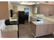 Functional kitchen featuring granite countertops, black appliances, and wood-look flooring at 1517 Danbury Dr, Sun City Center, FL 33573