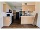 An open-concept kitchen featuring wood floors, lighter cabinets, and black appliances at 1517 Danbury Dr, Sun City Center, FL 33573