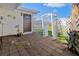 Private backyard patio with a palm tree and white pergola with a gate to the grassy area at 1517 Danbury Dr, Sun City Center, FL 33573