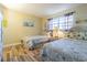 This is a bedroom with two twin beds and wood laminate flooring at 1750 Belleair Forest Dr # A7, Belleair, FL 33756