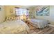 Bedroom with two twin beds, wood laminate flooring, and tropical decor at 1750 Belleair Forest Dr # A7, Belleair, FL 33756